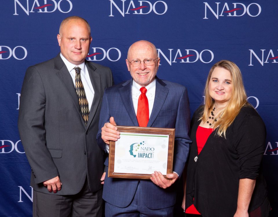 TCOG Executive Director, Eric Bridges (left), with NADO 2018-19 President Scott Koons (center), and TCOG CSBG Specialist Bobbie McDonald (right) being presented with the 2019 NADO Impact Award